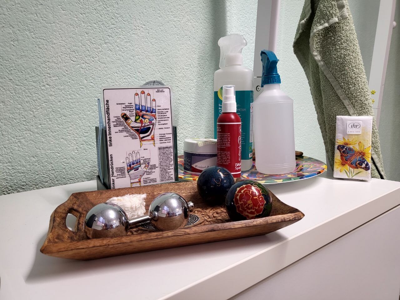 Massagekugeln und Handreflexzonen-Karten auf einem Holztablett